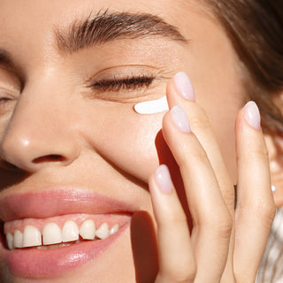 A user using the cream under her eyes